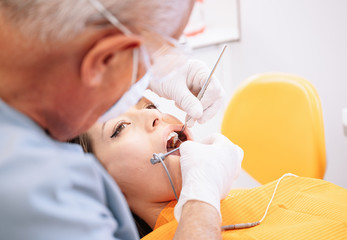 Male dentist healing teeth of woman