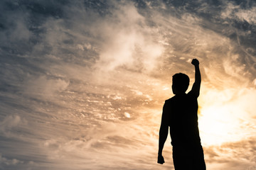 Wall Mural - Strong young man with fist in the air standing on top a mountain. Triumph, victory and feeling determined.