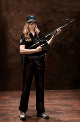 Wall Mural -  young blonde girl in uniform with gun