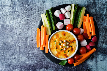 Hummus appetizer with carrot, radish, tomato and cucumber