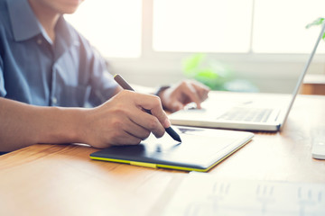 Fototapete - Working from home web designing graphical user interface UX UI, home office using computer laptop and pen sketching graphics tablet device creative planning innovative ideas, asian man quarantine