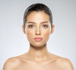 Wall Mural - Beautiful face of young caucasian woman with perfect health fresh skin.  Skin care concept. Closeup face of a  white brunette woman looking to the camera. Perfect skin of a caucasian adult girl