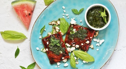 Sticker - Grilled watermelon with goat cheese and pesto sauce. dish of watermelon.  top view.