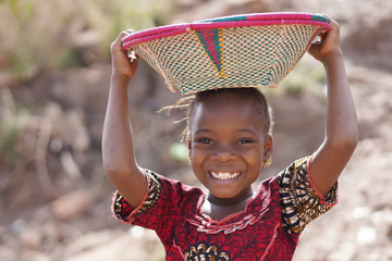 smiling african ethnic girl outdoors with food basket, poverty symbol