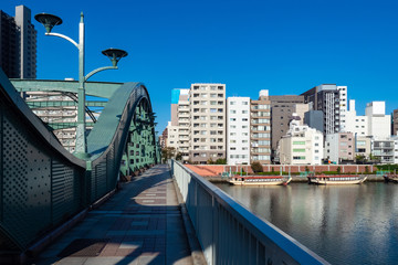 Wall Mural - Japan. Tokyo Bridges. Bridge over the river in the capital of Japan. Rivers Of Tokyo. Residential areas of Tokyo. The houses are located on the shore. Pleasure ships are moored off the coast.