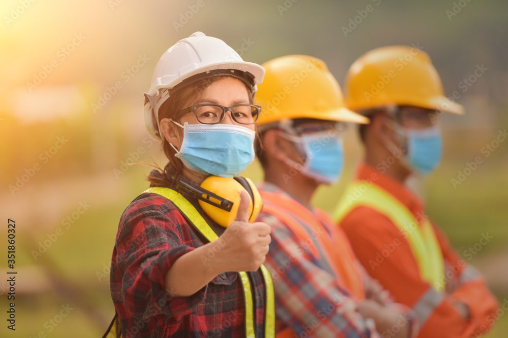 Corona or Covid-19 wear masks during the design of construction. New normal.Industrial engineering team wears a COVID 19 protective mask. Workers wear a quarantine face mask. - obrazy, fototapety, plakaty 