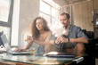 © pressmaster - Contemporary young man smoking e-cigarette while sitting next to his wife