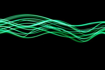 Wall Mural - Long exposure photograph of neon green colour in an abstract swirl, parallel lines pattern against a black background. Light painting photography.