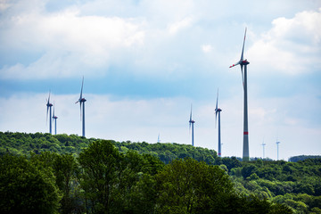 large piece of forest and in the middle of it a large wind farm with many wind turbines