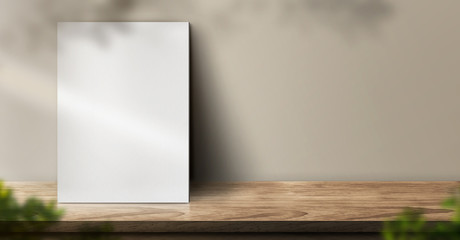 Fototapete - blank poster on wood table background with sunlight window create leaf shadow on wall with blur indoor green plant foreground.panoramic banner mockup for display of product,warm tone lights