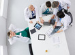 © lenets_tan - Medical team sitting and discussing at table, top view