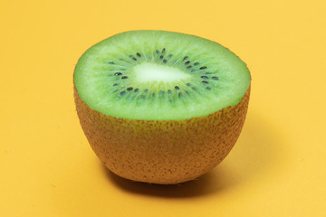 kiwi fruit slice on yellow background macro