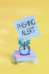 Poster - Handwriting text Phishing Alert. Conceptual photo aware to fraudulent attempt to obtain sensitive information Metal alarm clock blank sticky note stacked notepads colored background