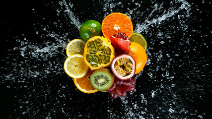 Wall Mural - Super Slow Motion Shot of Fresh Fruits with Splashing Water Isolated on Black Background.