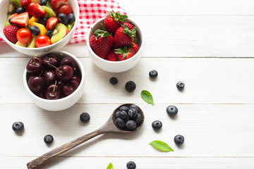 Wall Mural - Healthy foods  Concept , blueberry  strawberry apple  with salad  in  bowl on white wood background