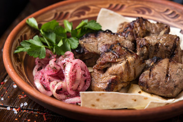 Grilled meat on pita with pickled onions and herbs