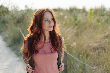 Young woman hiking through coastal dunes