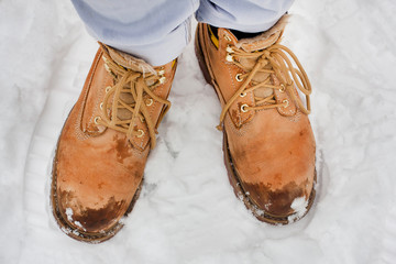 Yellow boots in winter snow during cold hiking