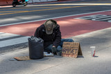 Fototapeta Miasta - New York, USA - MAY 10, 2020: A homeless man sitting on the street asking for help