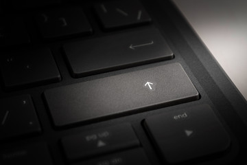 computer or laptop keyboard key with up arrow, enter, growth up, close-up