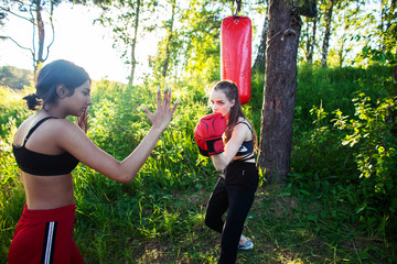 two diverse nations girls fighting boxing outside in green park, sport summer people concept