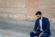 © tavi004 - Young business man with white shirt and suit in outdoor city looking at phone