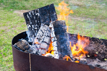 burning firewood in the grill for cooking meat and sausages.