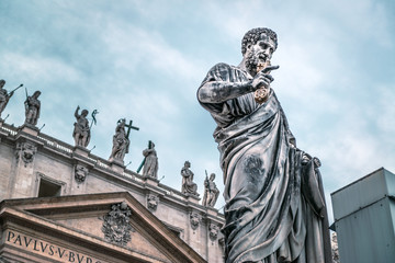 Wall Mural - Statue of Apostle Peter in front of St Peter's Basilica, Rome, Italy. Renaissance sculpture of apostle with key on dramatic sky background.