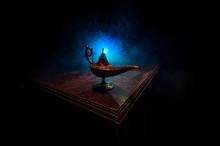 Lamp Of Wishes Concept. Antique Aladdin Arabian Nights Genie Style Oil Lamp With Soft Light White Smoke, Dark Background.