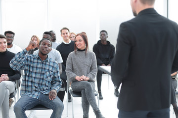 Wall Mural - speaker and a group of diverse young listeners in a conference room