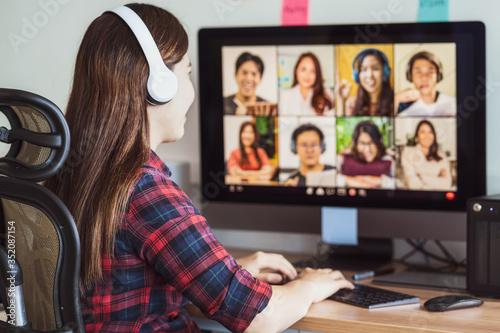 Fotografía Rear view of Asian woman working and online meeting via video conference with co
