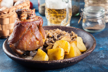 Canvas Print - Pork knuckle with fried sauerkraut and baked potatoes