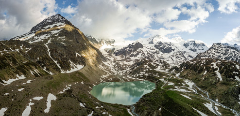 Wall Mural - glacier lake in the swiss alps during spring with clouds, blue sky and snow taken with a drone