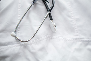 Close up of a stethoscope in a doctor's white lab coat. Doctor coat with a stethoscope.