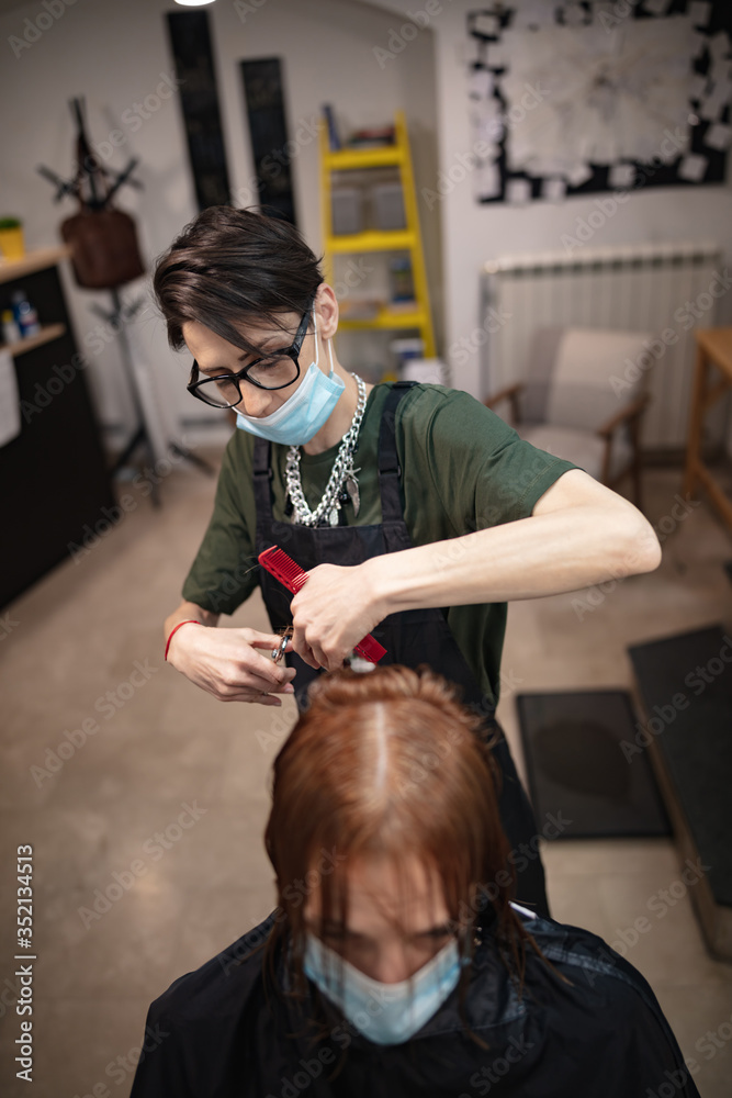 Hairdresser and customer in a salon with medical masks during virus pandemic. Working with safety mask. - obrazy, fototapety, plakaty 