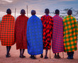 Masai tribesmen side-by-side in colourful, traditional dress, with spears from the back.
