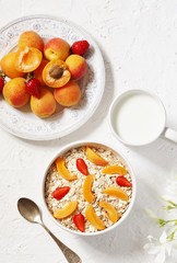 Wall Mural - breakfast with oatmeal and fruit, apricot and strawberries with milk. Summer season, fresh fruits, copy space