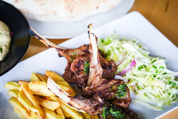 Wall Mural - delicious grilled lamb chopsticks with french fries, pesto sauce & mix of lettuces