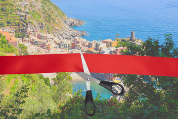 Wall Mural - End of quarantine covid-19. The beginning of travel, the opening of borders. Scissors cut the red ribbon overlooking the picturesque village of Vernazza, Italy