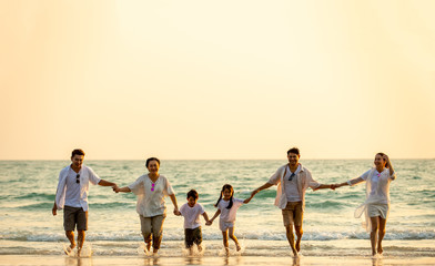 Wall Mural - Group of Happy multi generation Asian family relax and having fun together on tropical beach in summertime. Smiling big family parents with child boy and girl enjoy in summer lifestyle travel vacation