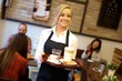 Happy blonde waitress holding tray, working in cafeteria.