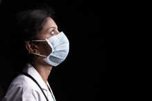 Profile View Of Young Woman Doctor With Opened Eyes In Medical Mask On Black Background Looking Up - Concept Of Hope And Fight To End Coronavirus Or Covid-19 Crisis.
