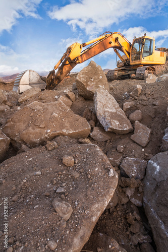 Fotomural Excavator in a quarry extracting stone