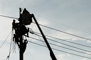 Electrician worker climbing electric power pole to repair the damaged power cable line problems after the storm. Power line support,Technology maintenance and development industry concept