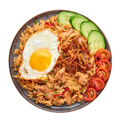 Nasi Goreng - Indonesian Chicken Fried Rice on black plate isolated on white backdrop. Nasi Goreng is an Indonesian cuisine dish. Balinese Food. Asian meal. Top view