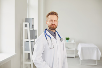 Wall Mural - Male doctor pediatrician standing in the white office of the hospital.