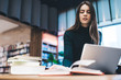 © GalakticDreamer - Smart woman with laptop reading book in library