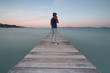 © Gustavo Muñoz - Man on a wooden pier talking on the phone in front of the sea with silky water on the island of Mallorca