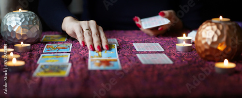 Cuadros en Lienzo Tarot reader picking tarot cards near burning candles.
