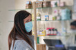 © jovannig - Woman wearing face mask in the pharmacy. Coronavirus emergency